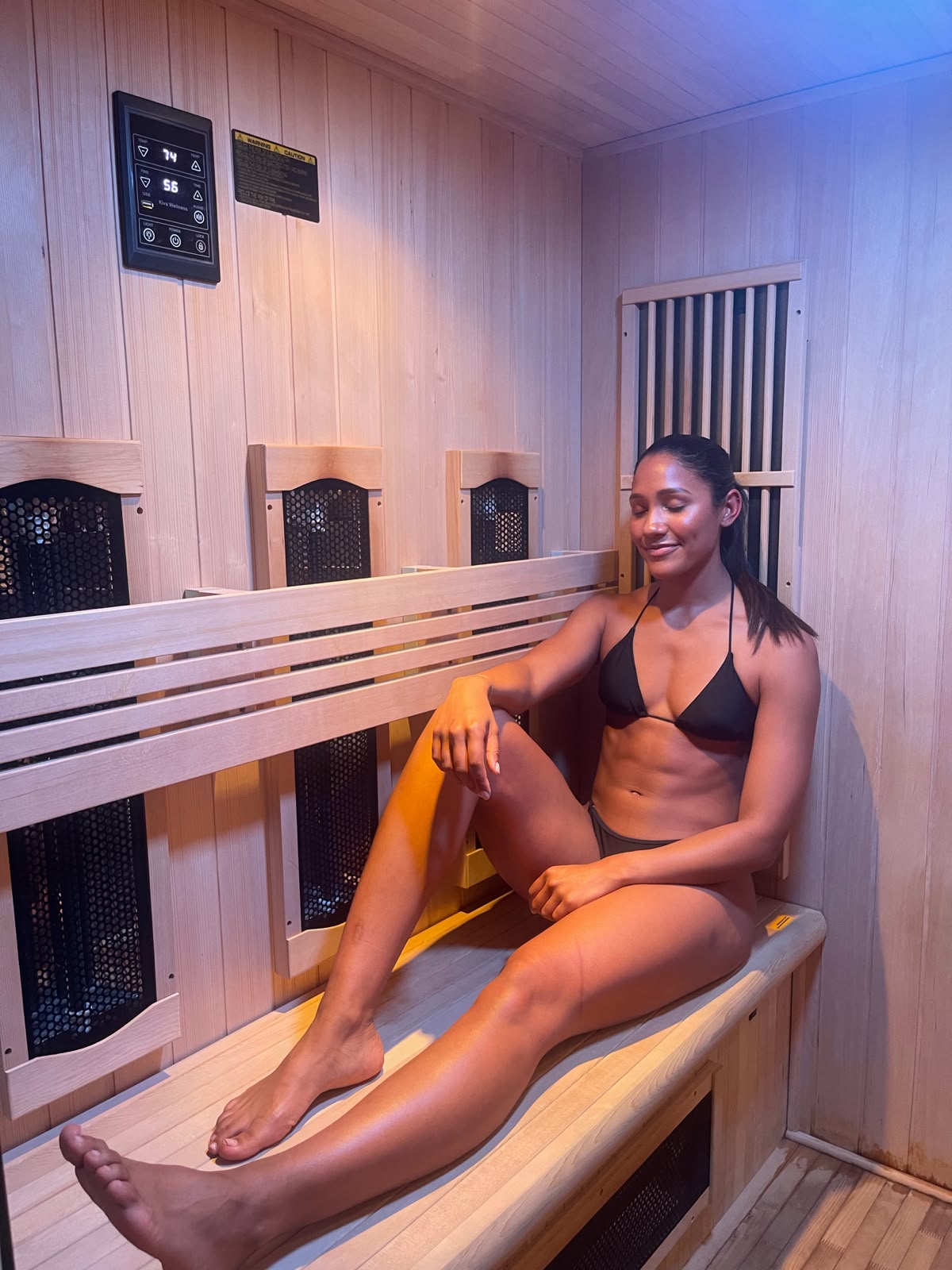 Woman relaxing in the timber infrared sauna at RE|HUB